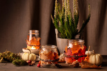 Autumn lantern jars decorated with colorful leaves and heather wreath