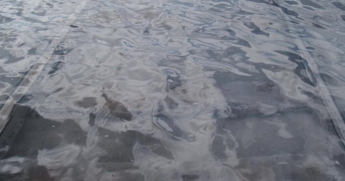 Transparent salt water in Dead Sea flooded railroad, dead heavily salty water spilled out of coast, small waves on water, glare of sun, travel to unusual places, railroad track covered with salt