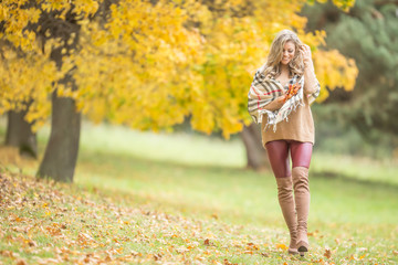 Young woman in autumn outfit emotional walk in park