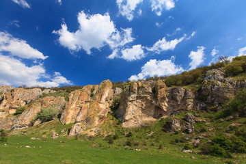Beautiful rock formations in a canyon in Romania, on a summer day, profiled on deep blue sky with cumulus clouds