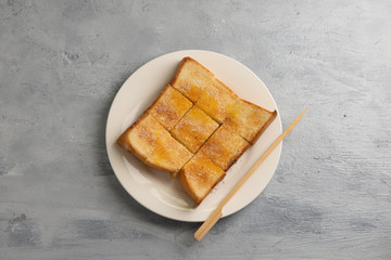 Bread toast with butter and condensed milk in plate. Selective focus