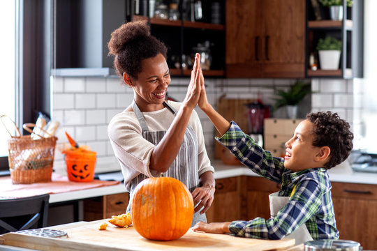 Mother with his son prepare pumpkin for halloween in the kitchen