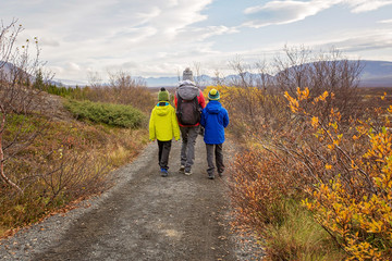 Mother with children, walking on a path in scenic Thingvellir National Park rift valley, Iceland