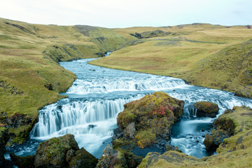 Fototapeta na wymiar Beautiful view of the Skogafoss waterfall in Iceland on a sunset cloudy day