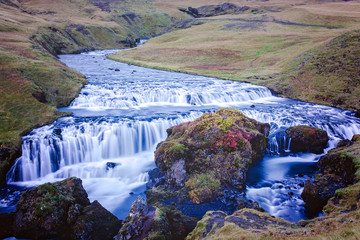 Fototapeta na wymiar Beautiful view of the Skogafoss waterfall in Iceland on a sunset cloudy day