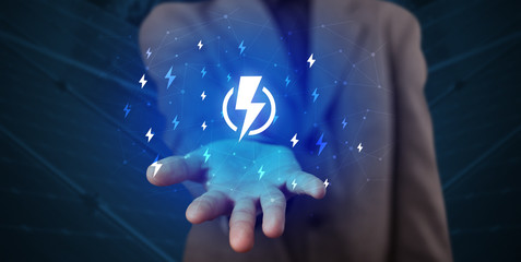 Hand in suit holding lightning bolt on his hand, green environment concept