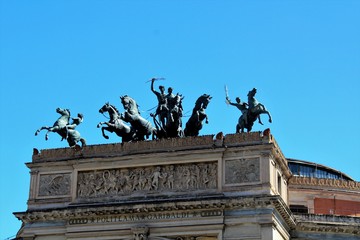 Fototapeta premium Palermo, Italy, September 07, 2019 - evocative image of the Politeama Theater in the city center, bronze quadriga with Apollo, god of music and Euterpe, muse of opera