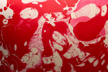 This a photograph of a Red and White abstract marbleized design created using nail polish