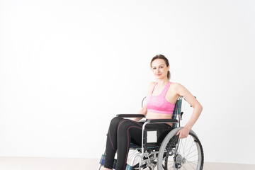 Obraz na płótnie Canvas スポーツウェアを着て車椅子に乗る外国人の女性