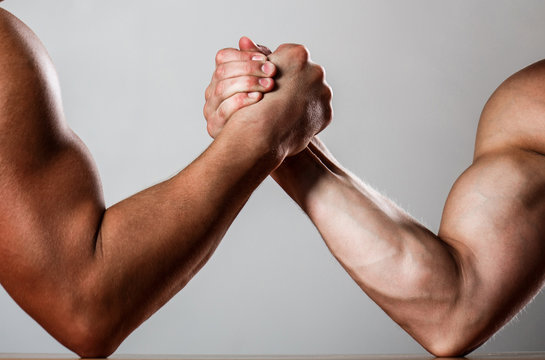 Hand wrestling, compete. Hands or arms of man. Muscular hand. Clasped arm wrestling. Two men arm wrestling. Rivalry, closeup of male arm wrestling. Muscular men measuring forces, arms