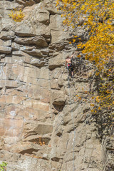 Rock climber fulfills rock climbing in natural conditions on a natural relief along unprepared routes