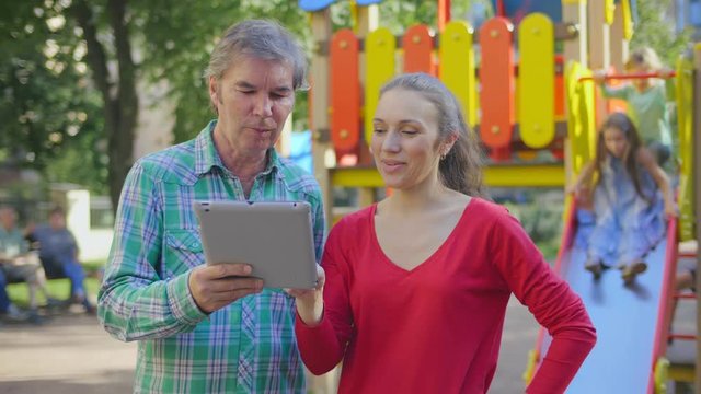 Parents using tablet outdoors