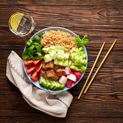 vegetarian poke bowl with vegetables and quinoa on a wooden table. Healthy food, vegetarian food....