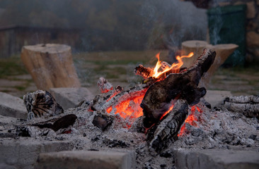 A dying fire in the rocks.Fog in the background.
