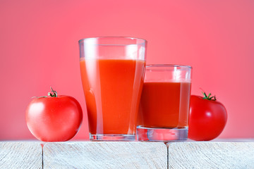 Glasses with fresh tomato juice on wooden table, closeup.