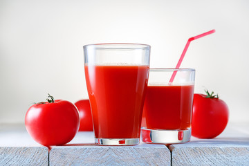 Two glasses of fresh tomato juice on wooden table. Healthy food and drink.