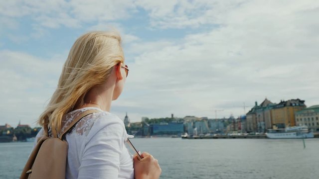Young tourist on the background of the city line of Stockholm, admiring the view of the city