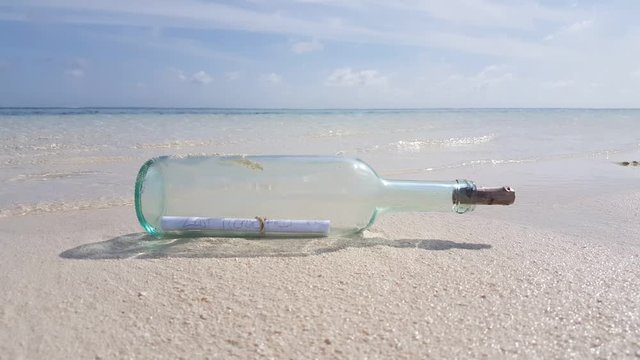 Message in the glass bottle on the beach sand 