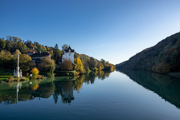 Fototapeta na wymiar old castel at the river in autumn blue sky