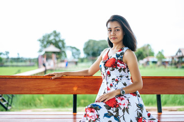 That woman sat on a wooden terrace and laid her hands on her legs.