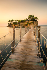 Fototapeta premium Beautiful sunrise at the famous Cameo island. A beautiful small island with wooden bridge and turquoise water. Zakynthos Greece. In summer.
