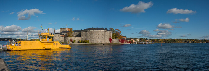 Autumn view with dust shaped clouds at Vaxholm in the Stockholm archipelago, boats, ferries and fortress.