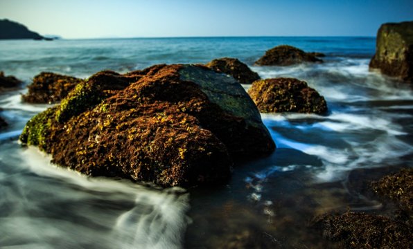 long exposure shot of sea waves and rocks on the Pollem beach, Goa