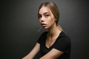Naklejka premium Fashion portrait of a sexy blonde woman with a make up wearing black clothes