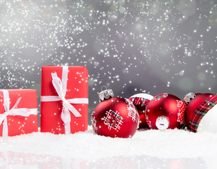 Christmas red balls and gifts in snow with blur holiday night  background. Free space for text 