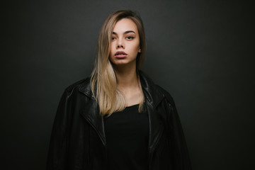 Fashion portrait of a sexy blonde woman with a make up wearing black clothes