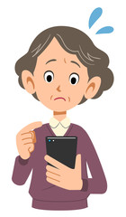 携帯電話を操作するシニアの女性の焦り