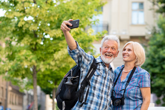 Cheerful senior tourists taking selfie