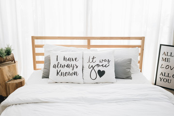 comfy wooden bed for couple decorated with "I have always known, It was you" heart pillow cosy bedroom at home valentines day, romantic date and holidays concept