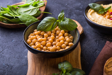 cooked chickpeas and homemade hummus  on a plate, stone background. yop view