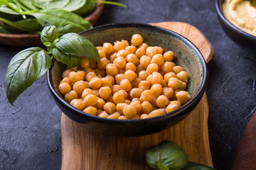cooked chickpeas and homemade hummus  on a plate, stone background. yop view