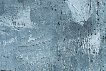 The texture of gypsum or alibaster cracked plaster on the wall is a thick layer. Gradient blue...