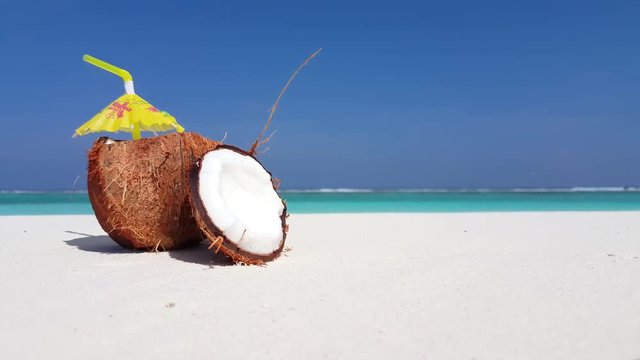 Coconut cocktail with  yellow umbrella on the white sand beach 