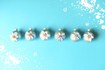  A row of decorative Christmas tree decorations on menthol background.