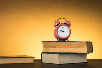 Symbolic hard study is powerful to succeed, concept with book and alarm clock. Time in business and quality