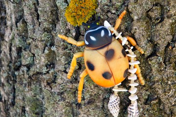 Figurine of a ladybug crawling on a tree