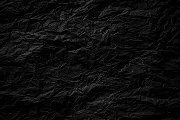 Dark black crumpled paper close up texture background