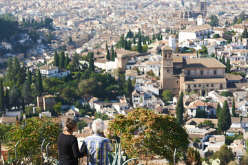  People in a viewpoint of the city of Granada contemplating beautiful views of this city.