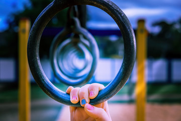 Closeup of girl's hand holding a monkey bar - shallow focus