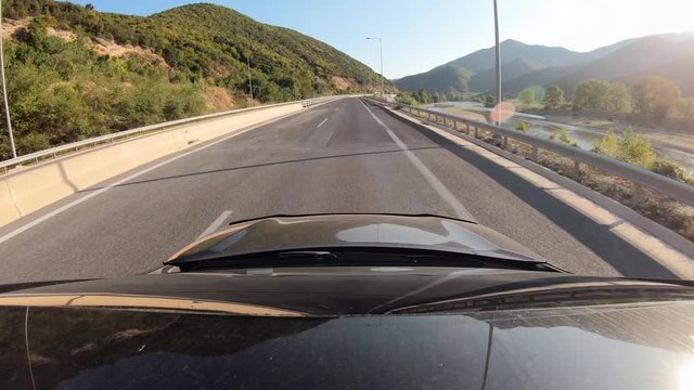Summer road trip on Europe, first-person view of a moving car on a highway.
