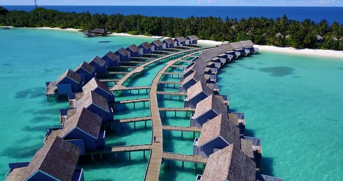 Tropical Travel Destination With Pristine Beach And Water Bungalows, Aerial Drone Shots Over The Water Accommodations
