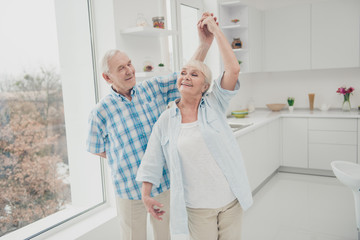 Portrait of charming sweet grandparents memory ballroom dancing kitchen enjoy kitchen room indoors