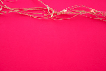 Illuminated garland lights on bright pink background