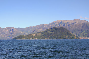 Landscape of Iseo Lake. View of the island Montisola. Alpine lake during a sunny day with a blue sky.