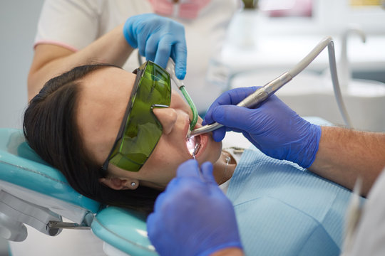 Doctor dentist treats teeth of a beautiful young girl patient. The girl on reception at the dentist. Doctor dentist treats tooth