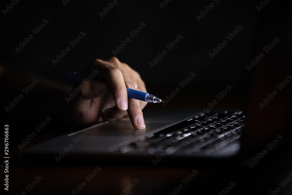 Poster hand of a man using laptop computer working at night